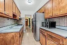 a kitchen with stainless steel appliances kitchen island granite countertop a refrigerator a stove and a sink with granite countertops