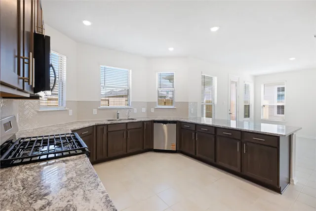 a large kitchen with stainless steel appliances and a sink