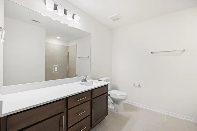 a bathroom with a double vanity sink a toilet and a mirror