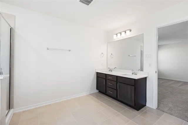 a spacious bathroom with a double vanity sink mirror and shower