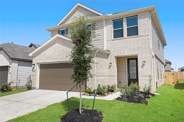 a front view of a house with a garden and plants