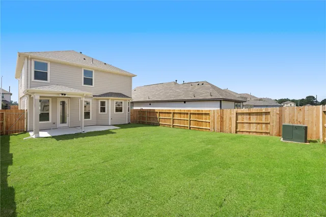 a view of a house with a yard deck and a large tree