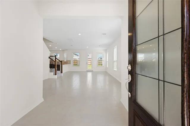 a view of a hallway with wooden floor and a living room