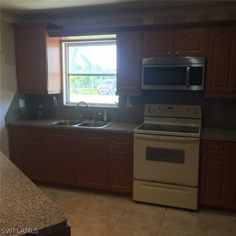 303 Davis Road Lehigh Acres, FL 33936 - Photo 3 of 17 a kitchen with a stove and a microwave