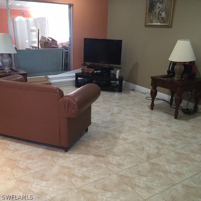 303 Davis Road Lehigh Acres, FL 33936 - Photo 6 of 17 a living room with furniture and a flat screen tv