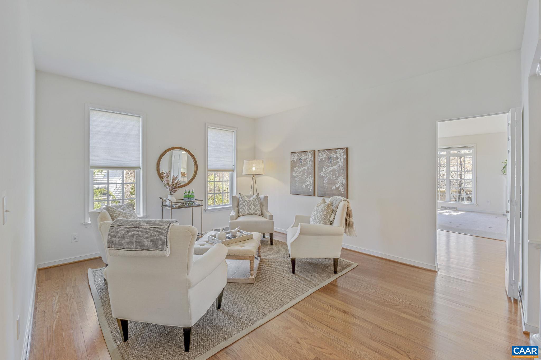 1347 Singleton Lane Charlottesville, VA 22903 - Photo 9 of 34 a living room with couches a large mirror and a dining table with wooden floor