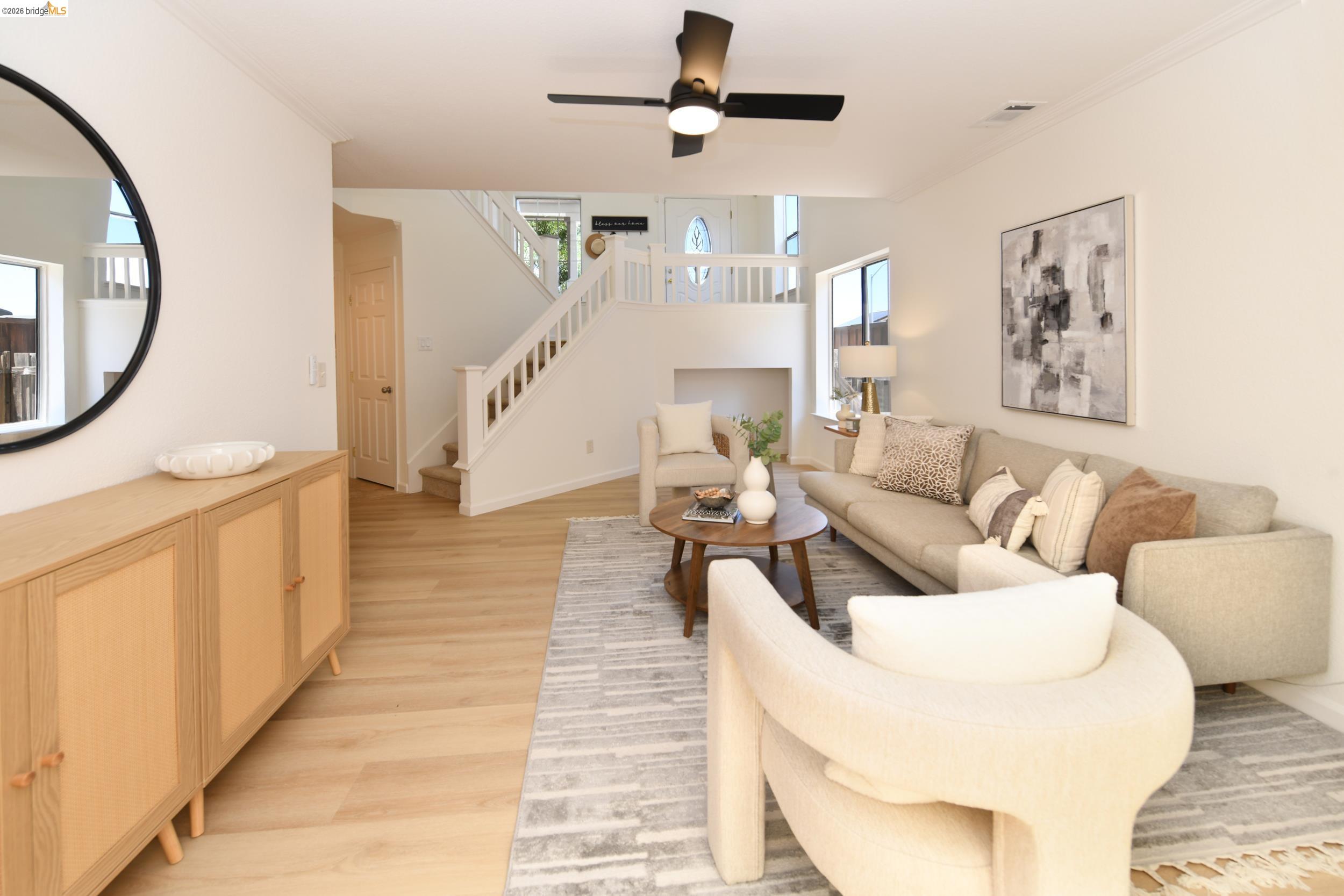 512 Burdick Drive Bay Point, CA 94565 - Photo 24 of 50 Open-concept living space featuring light wood-finish flooring, a contemporary ceiling fan, and a prominent staircase with white railings