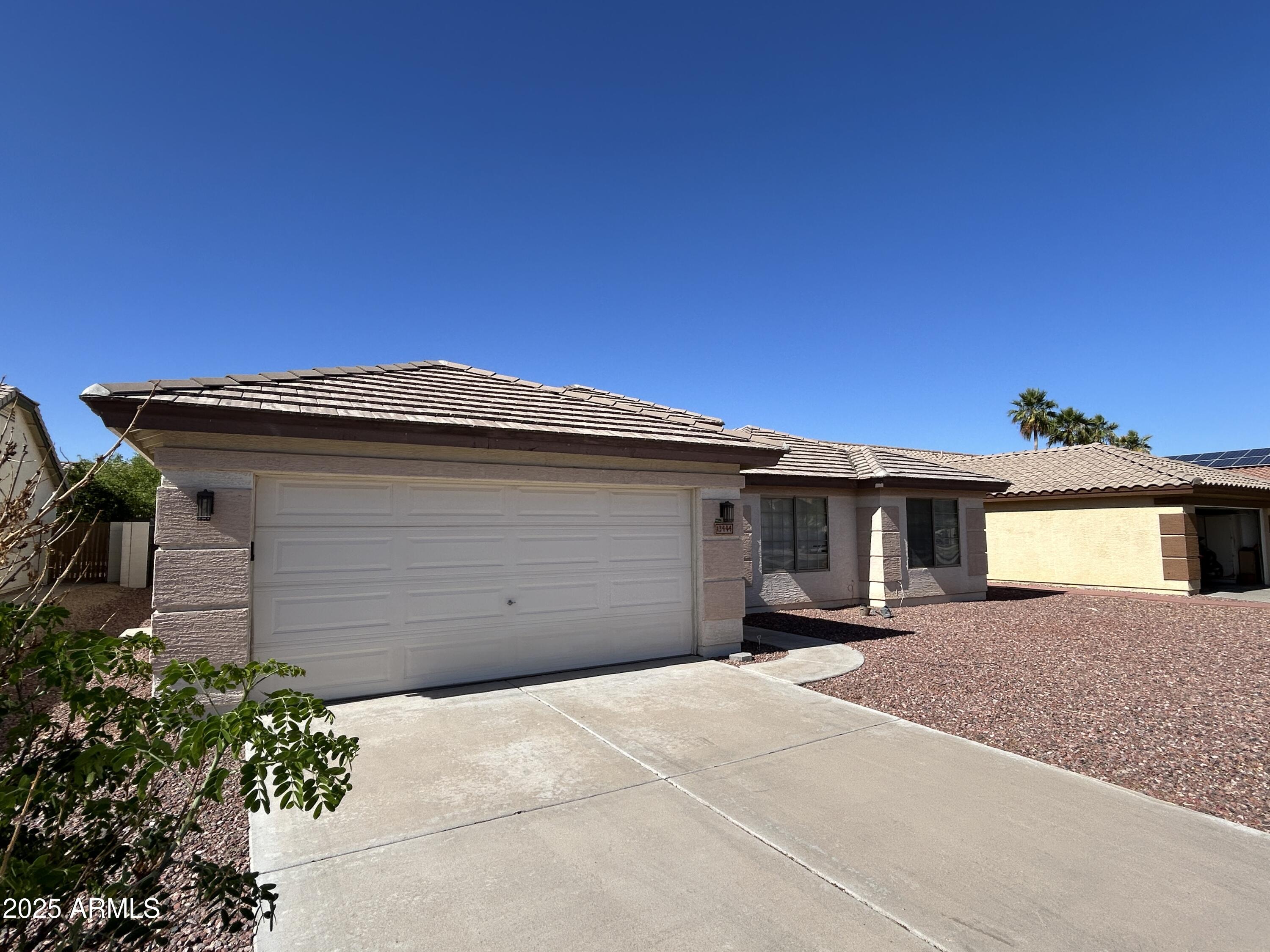13444 West Paradise Lane Surprise, AZ 85374 - Photo 4 of 25 a front view of a house with a garage