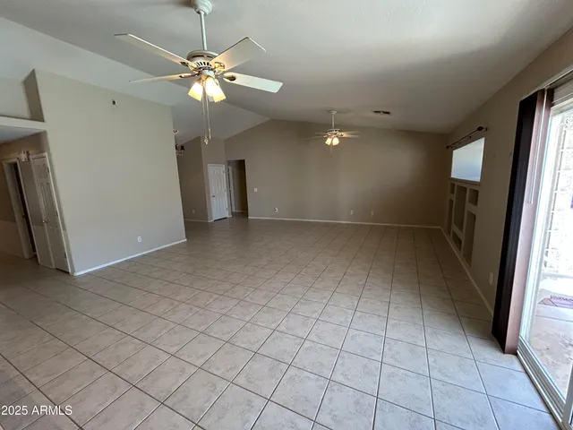 an empty room with fan and windows