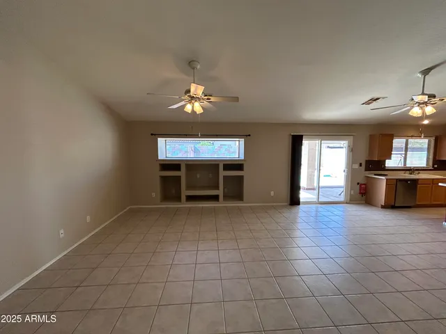 an empty room with windows and fireplace