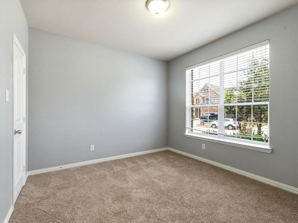 2364 Ranchview Drive Little Elm, TX 75068 - Photo 16 of 33 Neutral-toned wall paint, carpet flooring, a single window with blinds, and a flush mount light fixture