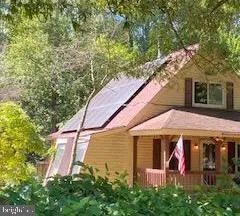 a view of a white house with large windows and a small yard