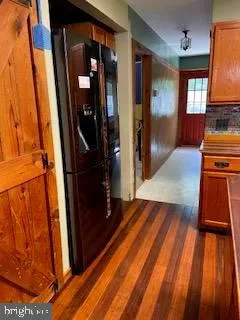 a kitchen with wooden floor and a large window
