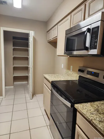 a kitchen with granite countertop a stove and a microwave