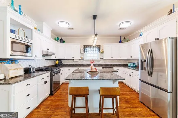 a kitchen with granite countertop a sink a stove and cabinets