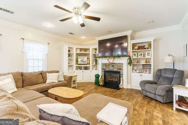 a dining room with stainless steel appliances kitchen island granite countertop a dining table chairs and white cabinets
