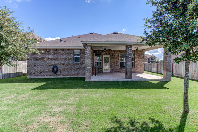 1237 Volente Lane Leander, TX 78641 - Photo 19 of 22 A spacious backyard with a covered patio offers ample room for outdoor activities and relaxation.