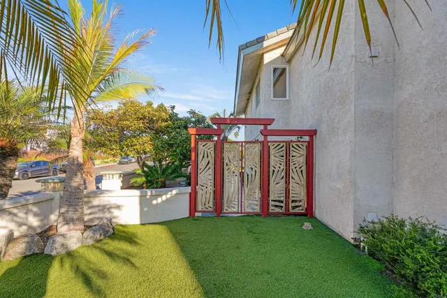 a patio with table and chairs and potted plants