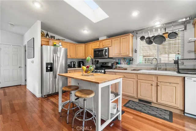 a kitchen with kitchen island granite countertop a sink appliances cabinets and furniture