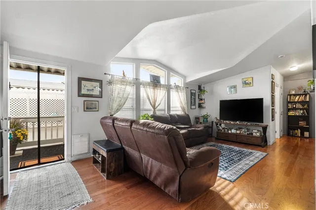 a living room with furniture a flat screen tv and a large window