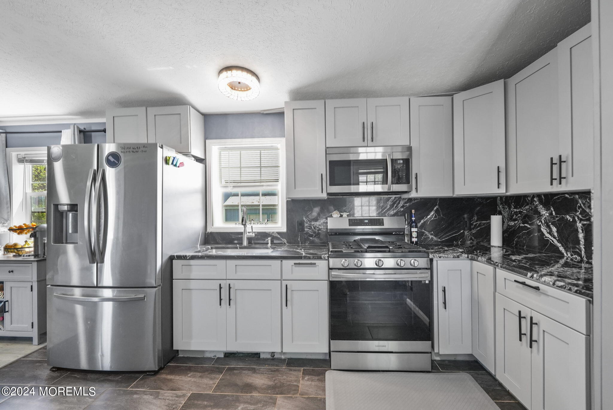 a kitchen with refrigerator a stove a sink and a microwave