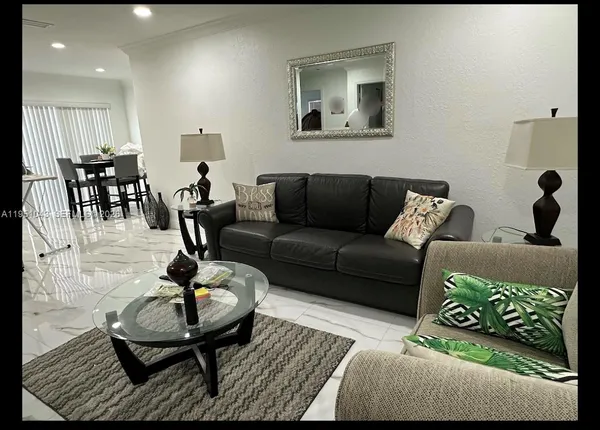 a living room with furniture and wooden floor