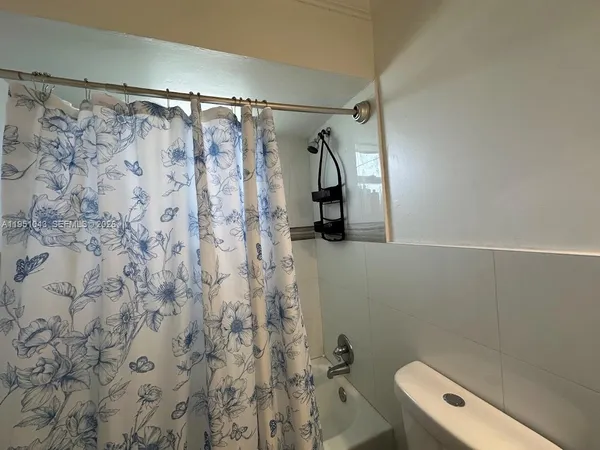a bathroom with a shower curtain and a toilet