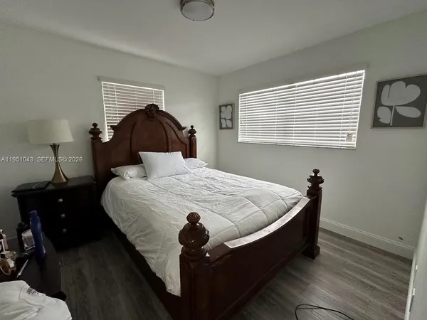 a bed sitting in a bedroom next to a lamp