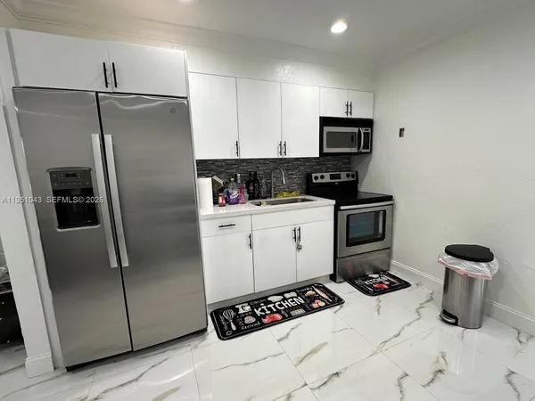 a kitchen with a refrigerator sink and stainless steel appliances