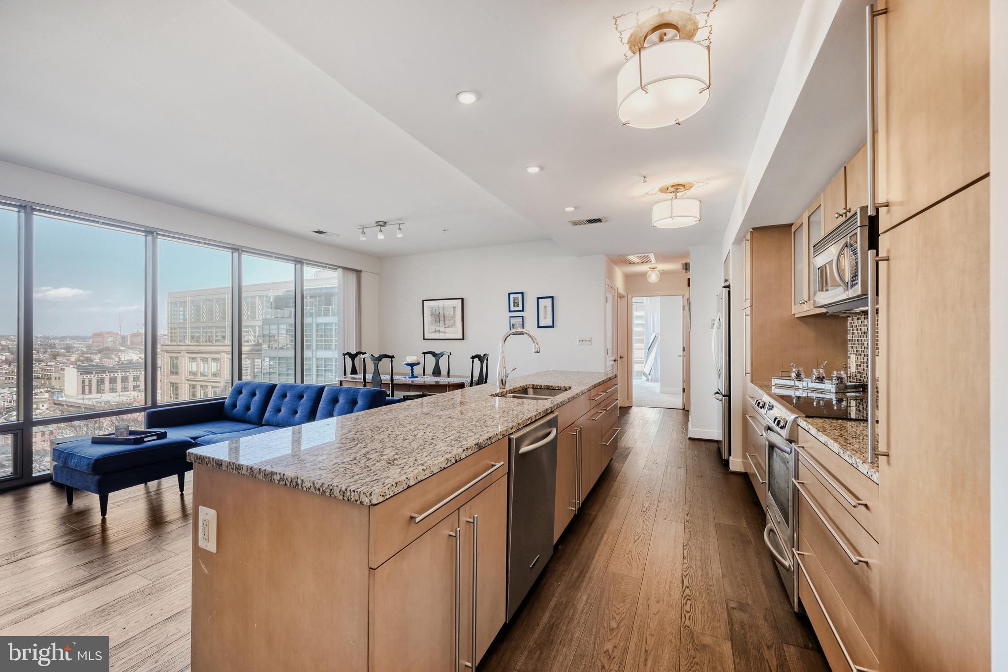 675 President Street, Unit 1406 Baltimore, MD 21202 - Photo 11 of 46 a large kitchen with kitchen island a large counter top space a large window a sink and stainless steel appliances