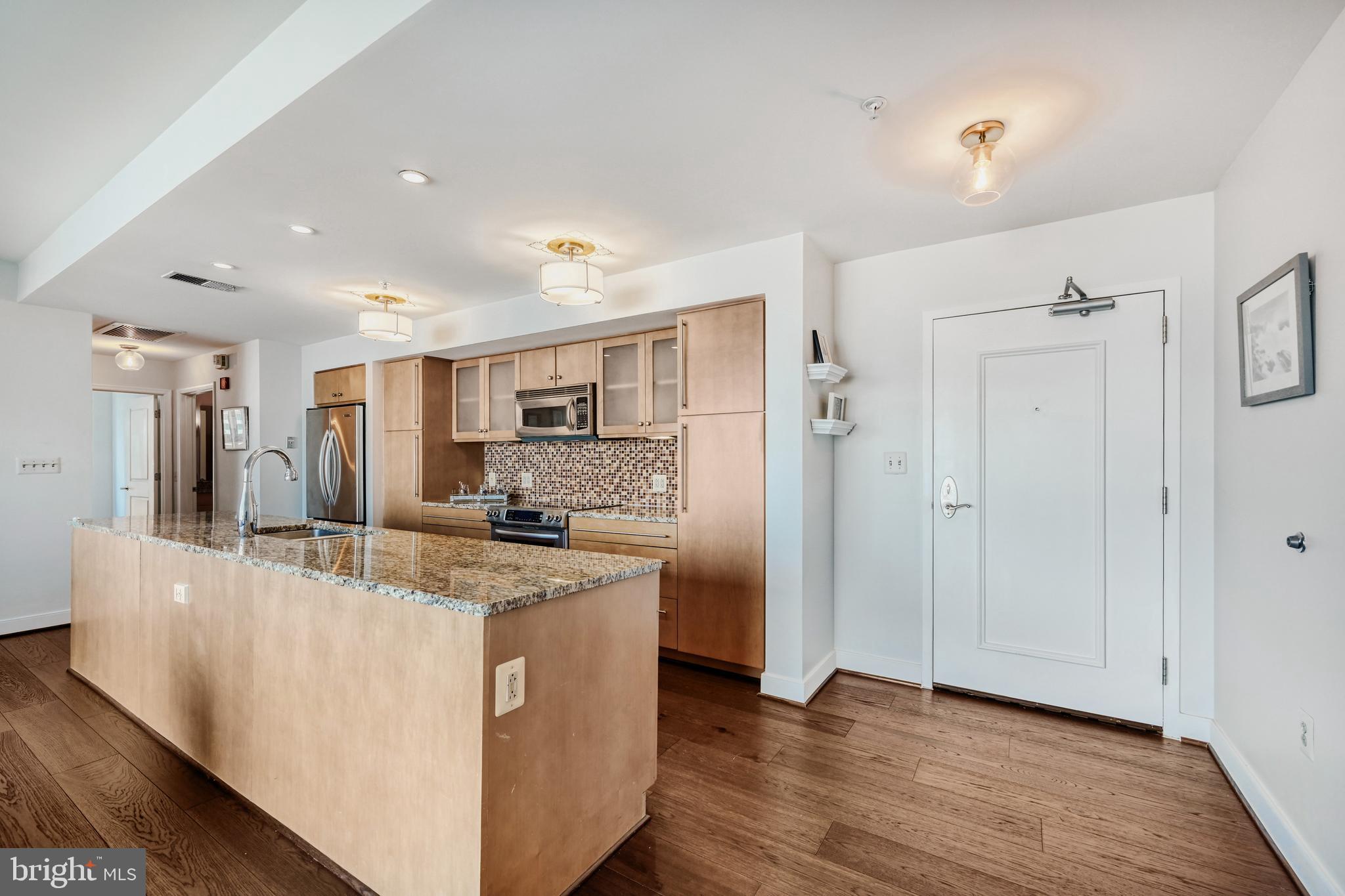 675 President Street, Unit 1406 Baltimore, MD 21202 - Photo 13 of 46 a large kitchen with stainless steel appliances granite countertop a large counter top and a wooden floors