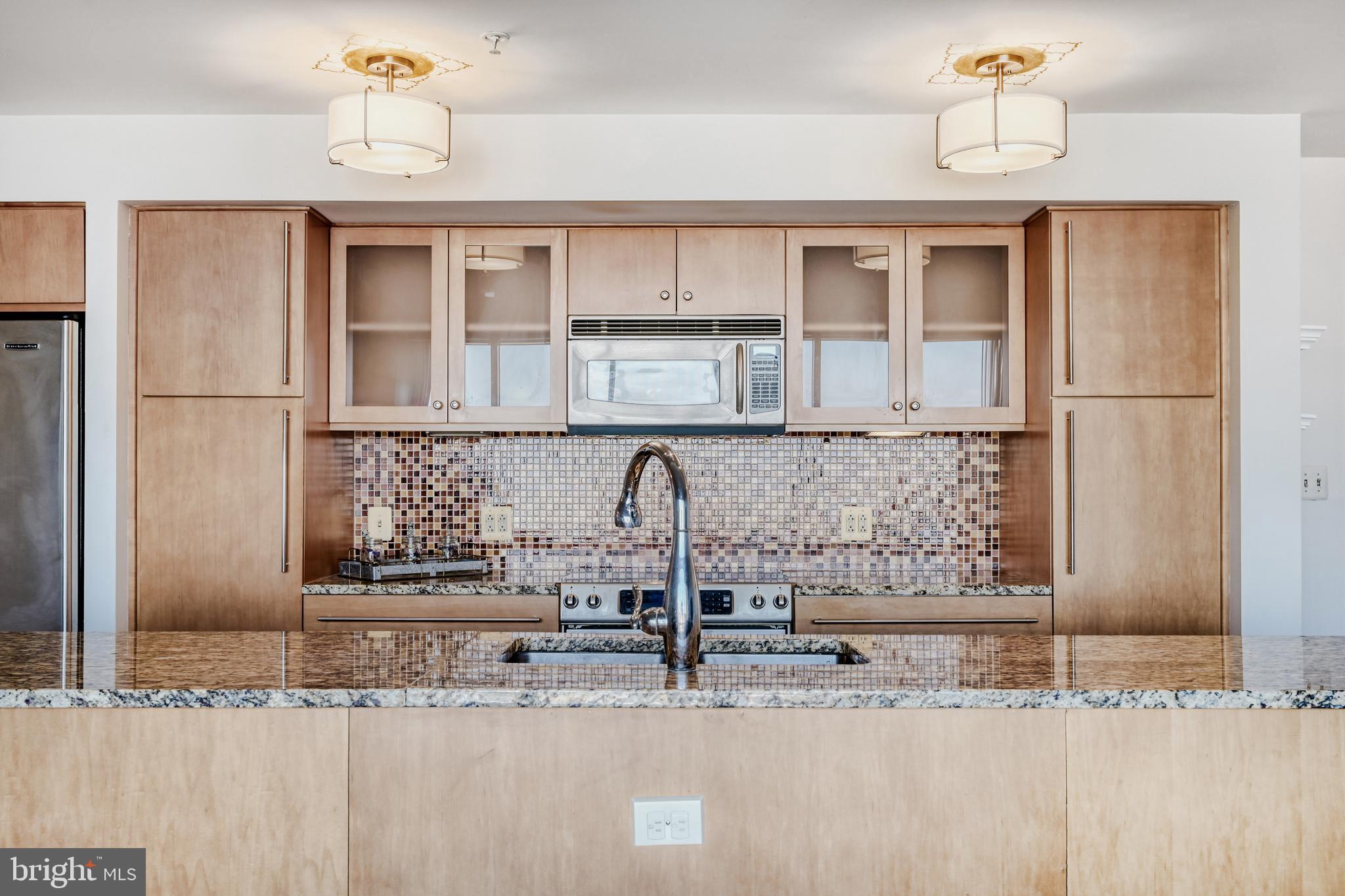 675 President Street, Unit 1406 Baltimore, MD 21202 - Photo 15 of 46 a kitchen with stainless steel appliances granite countertop a sink and cabinets