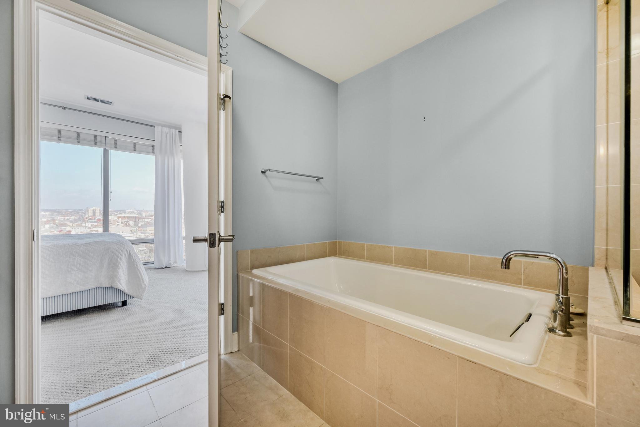 675 President Street, Unit 1406 Baltimore, MD 21202 - Photo 26 of 46 a bathroom with a tub a sink and a shower