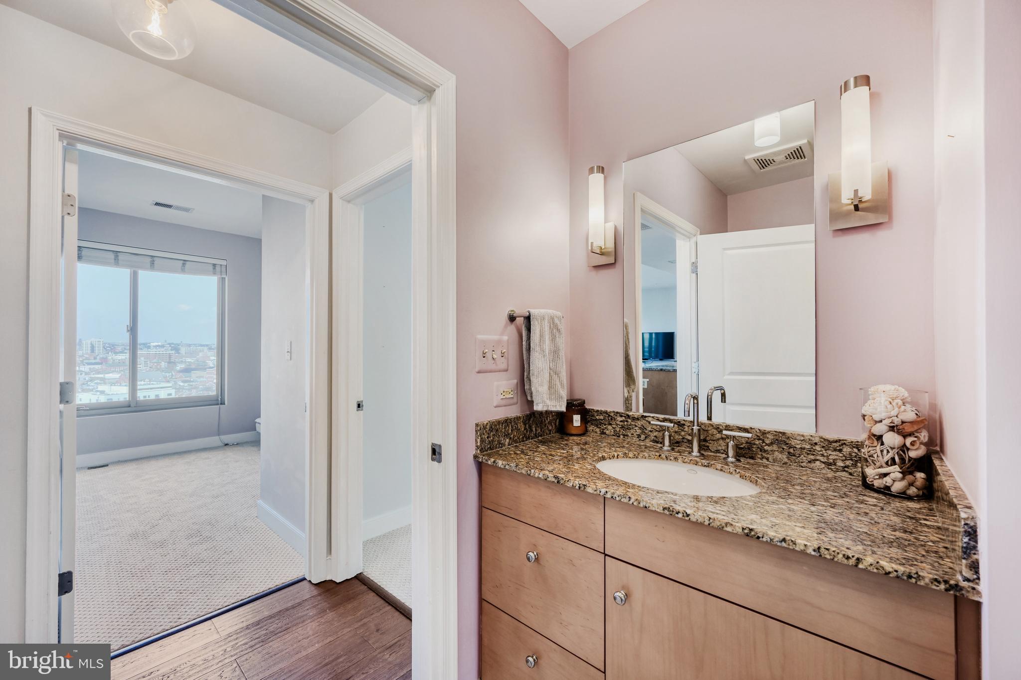 675 President Street, Unit 1406 Baltimore, MD 21202 - Photo 31 of 46 a bathroom with a granite countertop sink and a mirror
