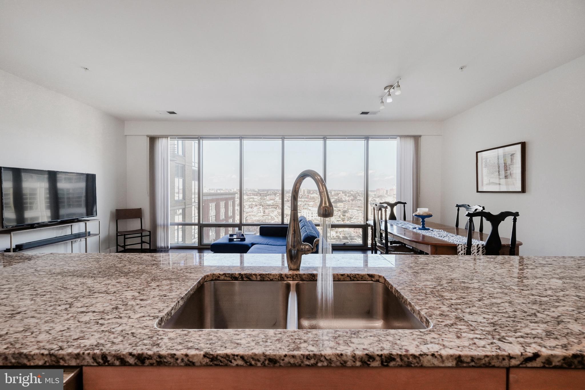 675 President Street, Unit 1406 Baltimore, MD 21202 - Photo 10 of 46 a kitchen with kitchen island a sink and a large window