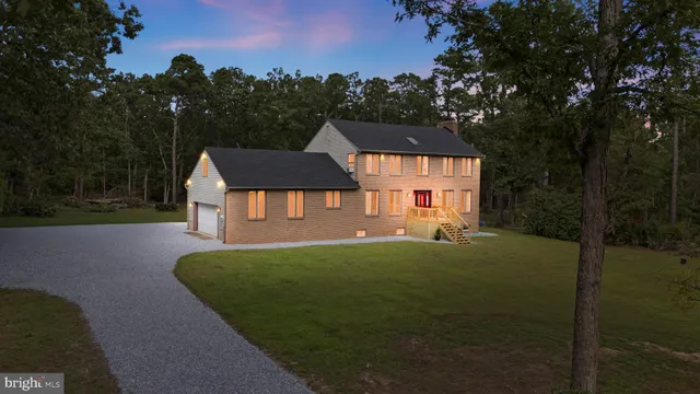 a front view of a house with a garden and yard