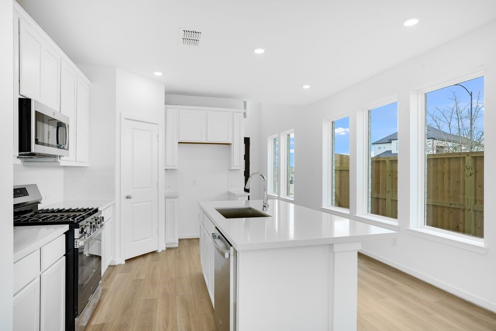 22130 Rangemore Drive Cypress, TX 77433 - Photo 3 of 36 a kitchen with stainless steel appliances a sink stove and cabinets