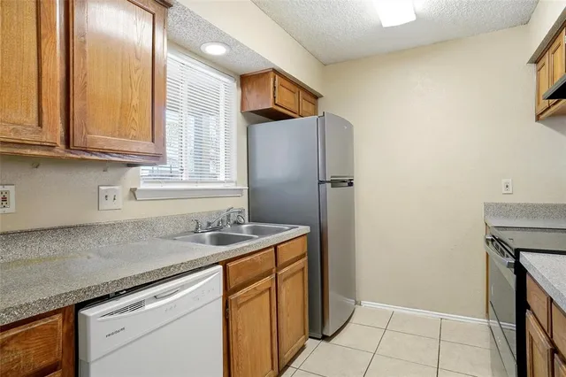 a kitchen with stainless steel appliances granite countertop a sink and a refrigerator