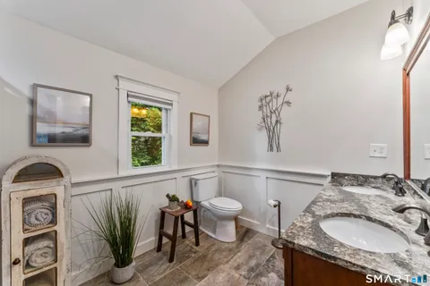 a bathroom with a granite countertop sink a large mirror and a window
