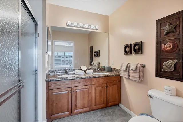 a bathroom with a granite countertop sink a toilet and a mirror