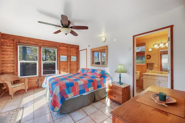 a bedroom with a bed and large windows