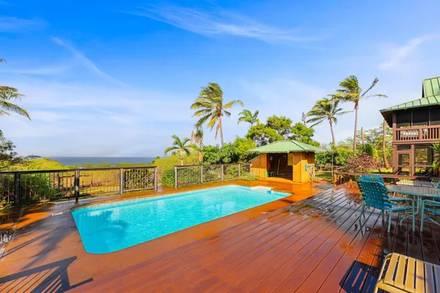 a backyard of a house with table and chairs potted plants with wooden floor
