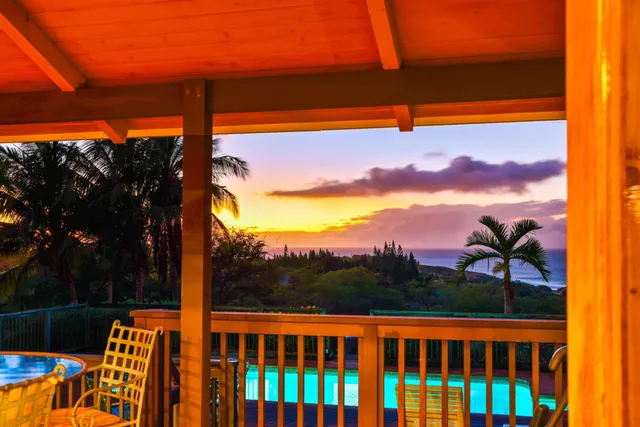 a roof deck with a table and chairs and potted plants with wooden floor
