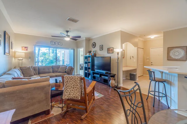 a living room with furniture a ceiling fan and a window