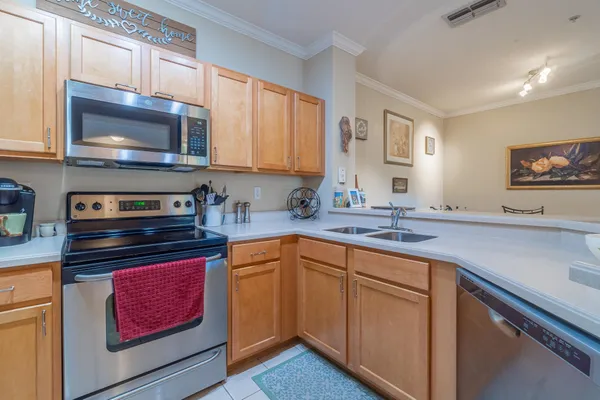 a kitchen with stainless steel appliances a stove microwave and sink