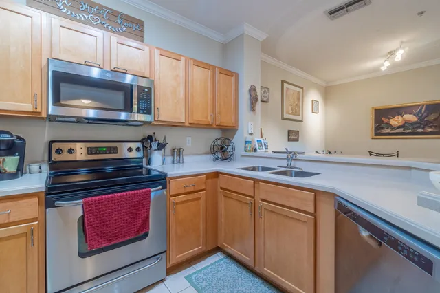 a kitchen with stainless steel appliances a stove microwave and sink