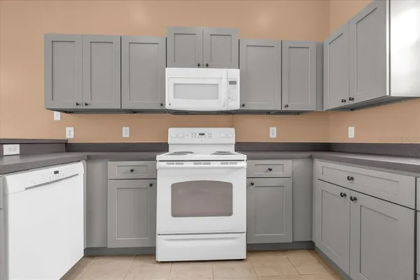 a kitchen with white cabinets and white appliances