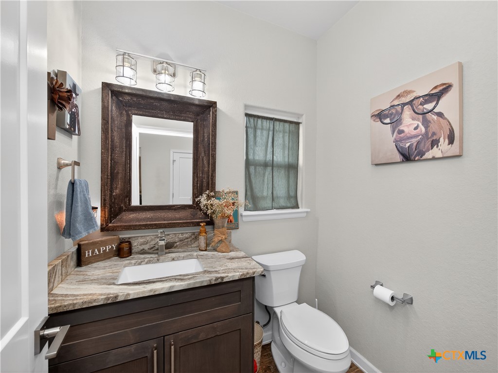 494 Flash Circle Luling, TX 78648 - Photo 28 of 44 a bathroom with a granite countertop sink vanity mirror and toilet