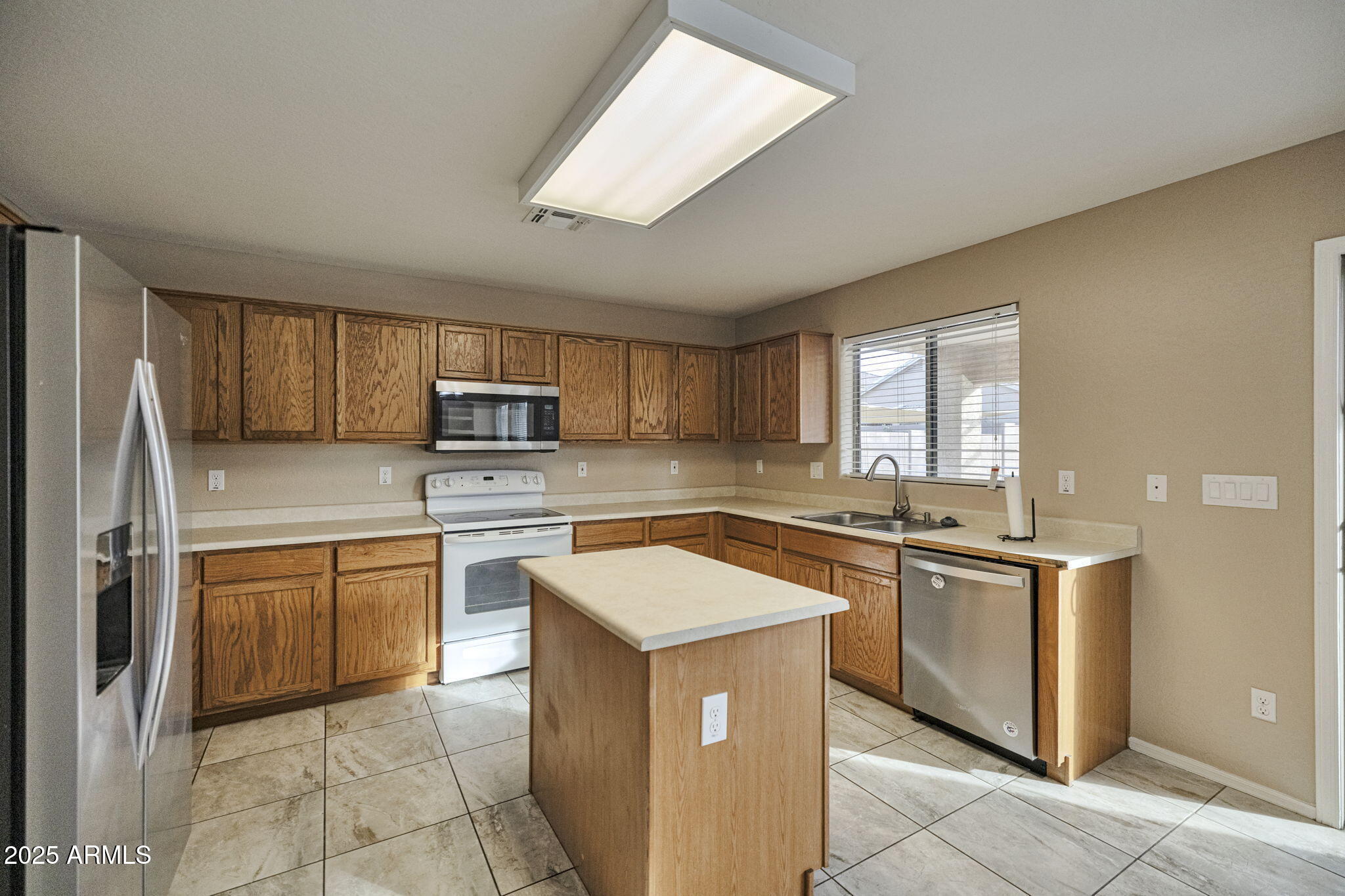 9705 West Riverside Avenue Tolleson, AZ 85353 - Photo 9 of 26 a kitchen with stainless steel appliances granite countertop a stove top oven sink and refrigerator
