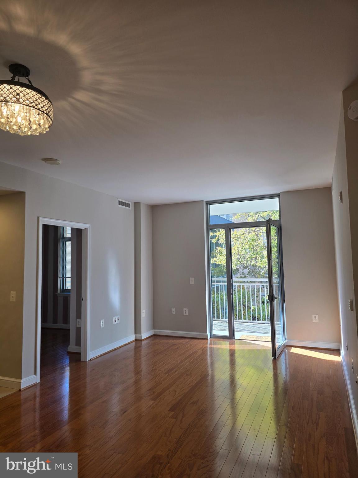 11990 Market Street, Unit 208 Reston, VA 20190 - Photo 14 of 16 wooden floor in an empty room with a window